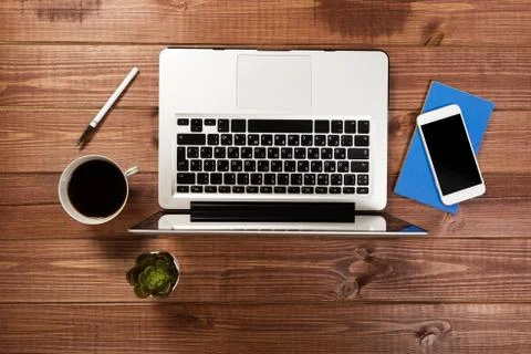 Office stuff with notepad, laptop and coffee cup mouse notepad top view shot. Stock Photos