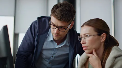 Office supervisor coaching intern closeup. Focused colleagues team analyse data Stock Footage 242981639
