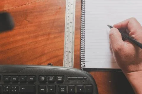 Office supply close up on top view with hand hloding pen on book ruler and co Stock Photos
