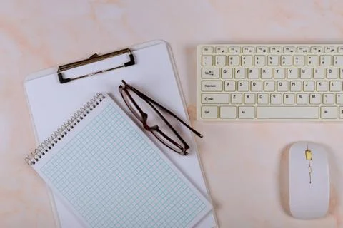 Office table with blank notebook and keyboard on a wooden table background. Stock Photos