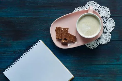 Office table with blank notebook and Coffee cup with chocolate Stock Photos