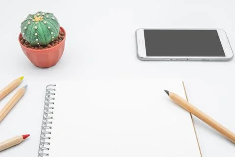 Office table with cactus, smartphone, notebook and pencil, top view, flat lay Foto stock