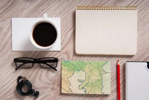 Office table with a coffee cup, a blank notepad and supplies Stock Photos