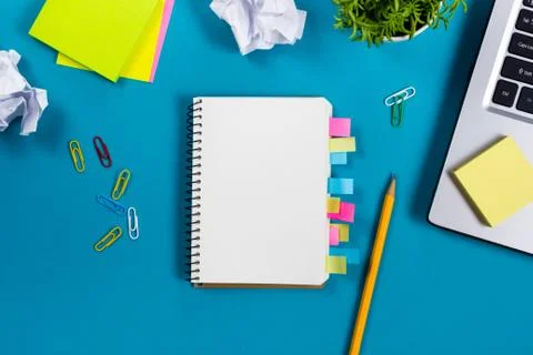 Office table desk with set of colorful supplies, white blank note pad, cup, pen Foto stock