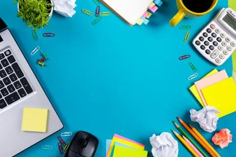 Office table desk with set of colorful supplies, white blank note pad, cup, pen Stock Photos
