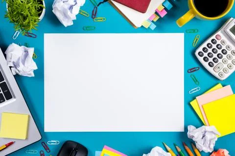 Office table desk with set of colorful supplies, white blank note pad, cup, pen Stock-Fotos