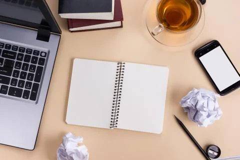 Office table desk with supplies, white blank note pad, cup, pen, pc, crumpled Stock Photos