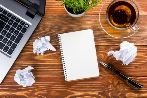 Office table desk with supplies, white blank note pad, cup, pen, pc, crumpled Stock Photos