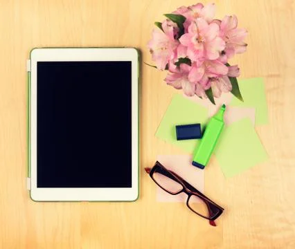 Office table with digital tablet, reading glasses and sticky notes.  Stock Photos