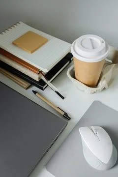 Office table flat lay: laptop, work note pads, pen, computer mouse and take.. Stock Photos