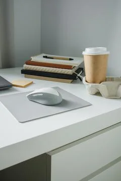 Office table flat lay: laptop, work note pads, pen, computer mouse and take.. Foto stock