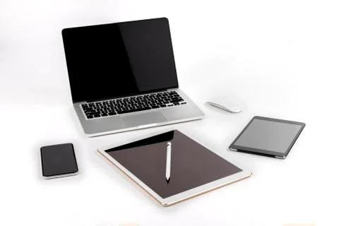 Office table with laptop computer, digital tablet, smartphone, pencil and mou Stock Photos