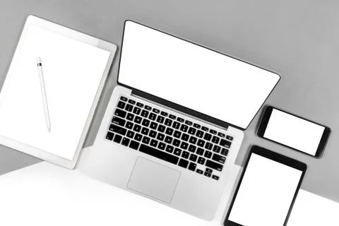 Office table with laptop computer, digital tablet, smartphone, pencil and mou Stock Photos
