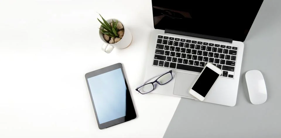 Office table with laptop computer, digital tablet and mobile phone on modern  Stock Photos