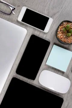 Office table with laptop computer, digital tablet, pen, smartphone, mouse, ey Stock Photos