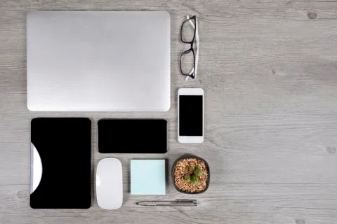 Office table with laptop computer, digital tablet, pen, smartphone, mouse, ey Stock Photos