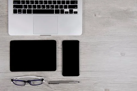 Office table with laptop computer, digital tablet, pen, smartphone and eyegla Stock Photos