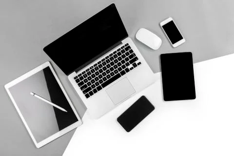 Office table with laptop computer, digital tablet, smartphone, pencil and mou Stock Photos