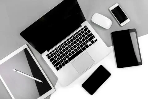 Office table with laptop computer, digital tablet, smartphone, pencil and mou Stock Photos