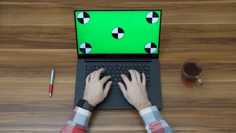 Office table with laptop computer with green screen and male hands taping on it. Stock Footage 87568967