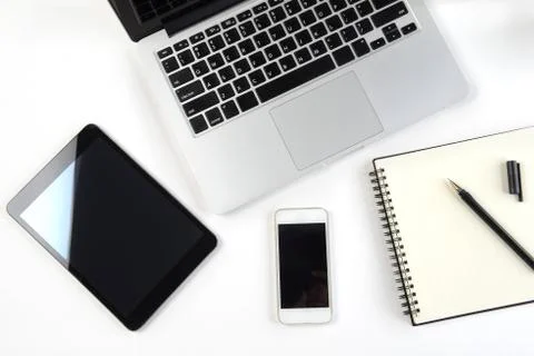 Office table with laptop computer, notebook, digital tablet and smartphone on Stock Photos