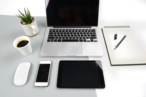 Office table with  laptop computer, notebook, digital tablet and smartphone o Stock Photos