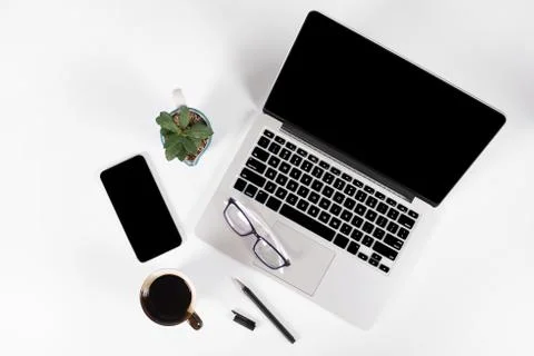 Office table with laptop computer, smartphone, pen, notebook and coffee on is Stock Photos
