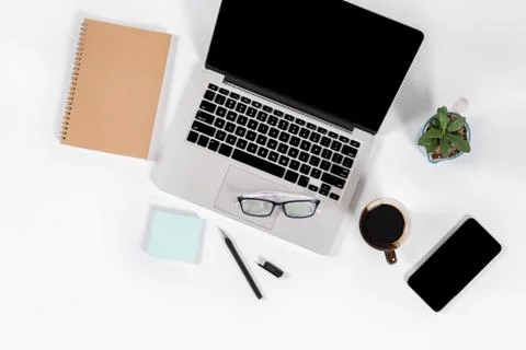 Office table with laptop computer, smartphone, pen, notebook and coffee on is Stock Photos