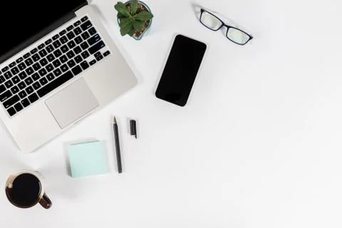 Office table with laptop computer, smartphone, pen, notebook and coffee on is Stock Photos