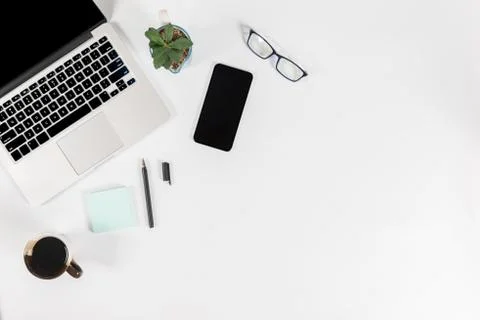 Office table with laptop computer, smartphone, pen, notebook and coffee on is Stock Photos