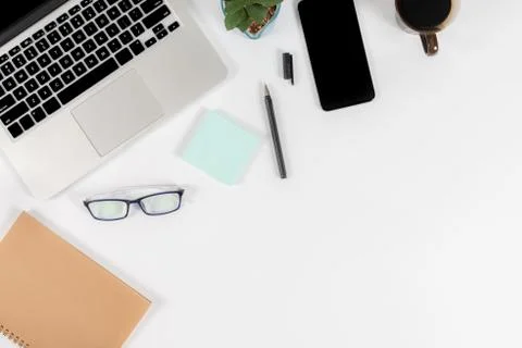 Office table with laptop computer, smartphone, pen, notebook and coffee on is Stock Photos