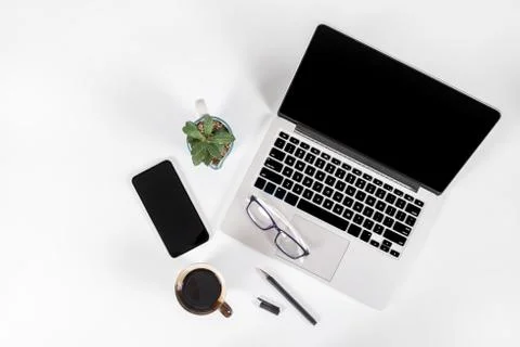 Office table with laptop computer, smartphone, pen, notebook and coffee on is Stock Photos