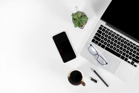 Office table with laptop computer, smartphone, pen, notebook and coffee on is Stock Photos
