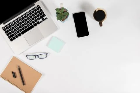 Office table with laptop computer, smartphone, pen, notebook and coffee on is Stock Photos