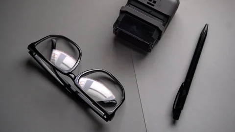 On the office table lie glasses and reflect the monitor 库存影片 83433818