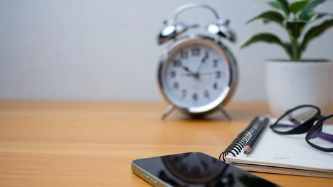 Office table of modern workplace with notebooks and pencils, phone, clock o.. Stock Photos