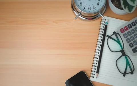 Office table of modern workplace with notebooks and pencils, phone, clock o.. Stock Photos
