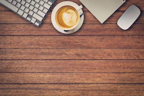 Office table with notepad, computer and coffee cup and computer mouse. View f Stock Photos