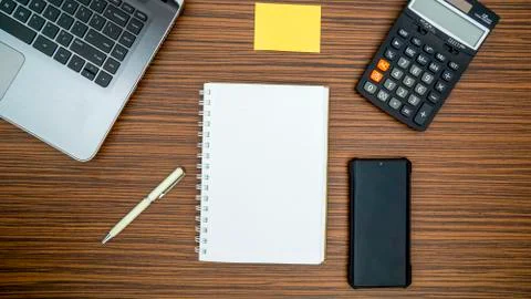 An office table working enviroment. Notepad, sticky note, pen plant, calculat Stock Photos