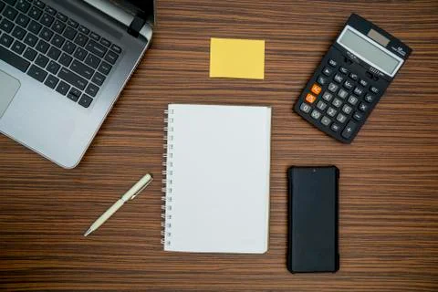 An office table working enviroment. Notepad, sticky note, pen plant, calculat Stock Photos