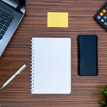 An office table working enviroment. Notepad, sticky note, pen plant, calculat Stock Photos