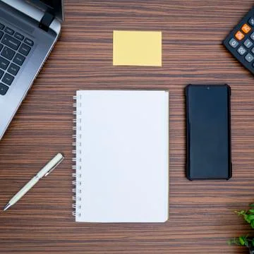 An office table working enviroment. Notepad, sticky note, pen plant, calculat Stock Photos