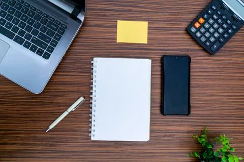 An office table working enviroment. Notepad, sticky note, pen plant, calculat Stock Photos