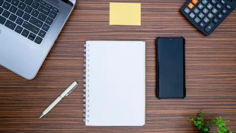 An office table working enviroment. Notepad, sticky note, pen plant, calculat Stock Photos