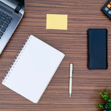 An office table working enviroment. Notepad, sticky note, pen plant, calculat Stock Photos