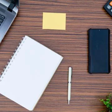 An office table working enviroment. Notepad, sticky note, pen plant, calculat Stock Photos