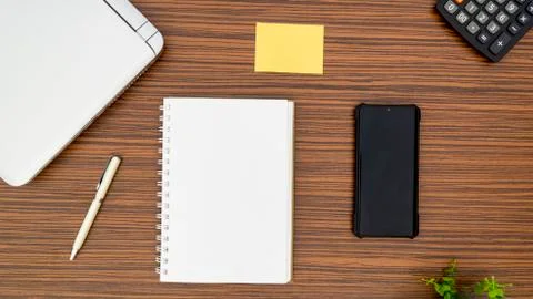 An office table working enviroment. Notepad, sticky note, pen plant, calculat Stock Photos