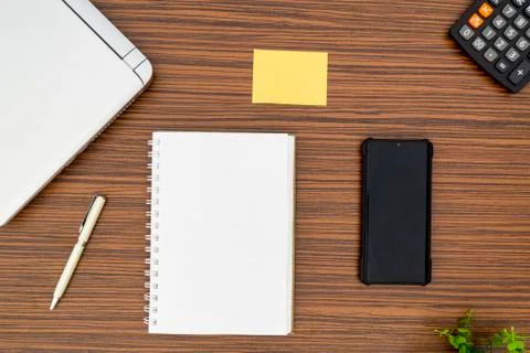 An office table working enviroment. Notepad, sticky note, pen plant, calculat Stock Photos