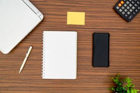 An office table working enviroment. Notepad, sticky note, pen plant, calculat Stock Photos