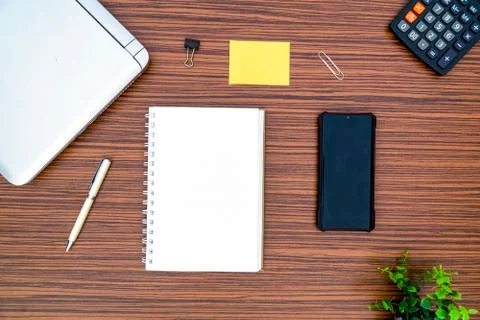 An office table working enviroment. Notepad, sticky note, pen plant, calculat Stock Photos